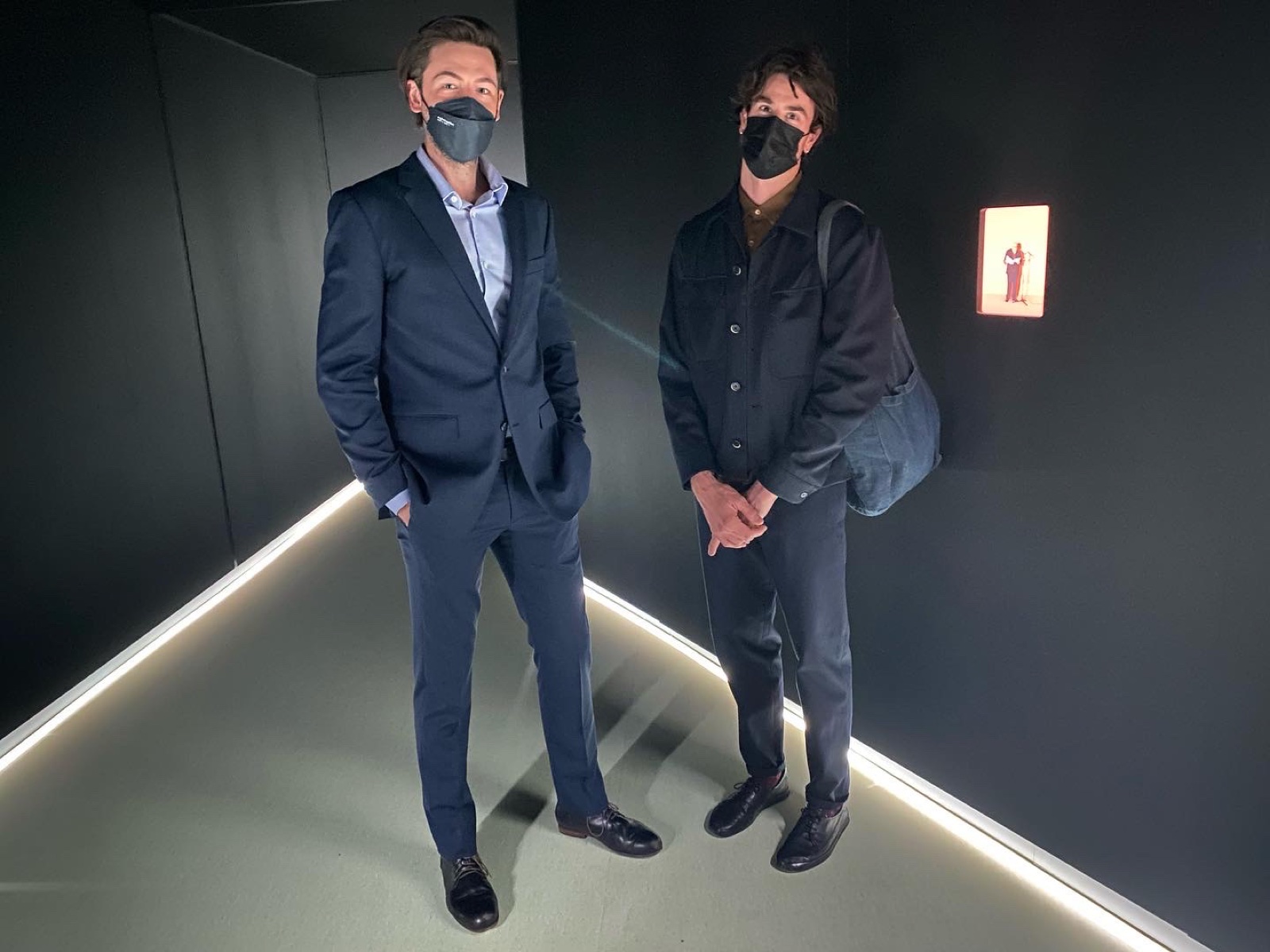 Visitors standing inside the dark multi-screen installation