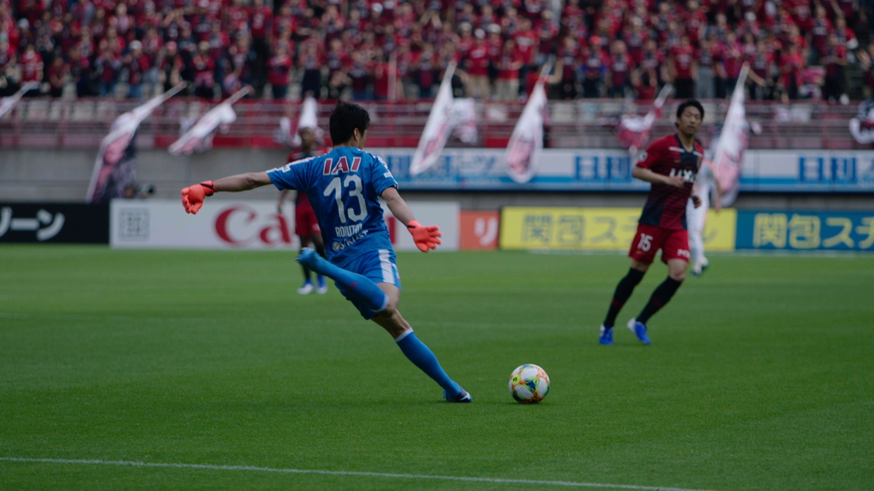 A footballer striking the ball during a match in Japan
