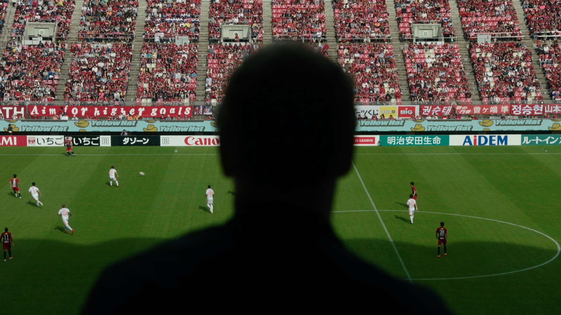 A football scout watching a match from the stands